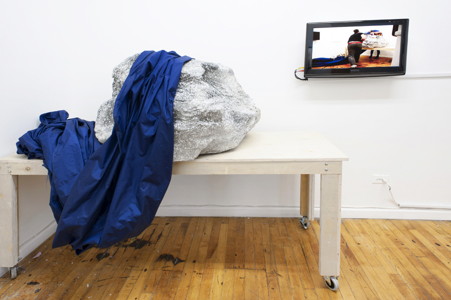 Six ways the water crashes over the shore 2012,  15 min. performance looped on DVD, Cast boulder, cloth, wooden table, 50 x 60 x 36 inches